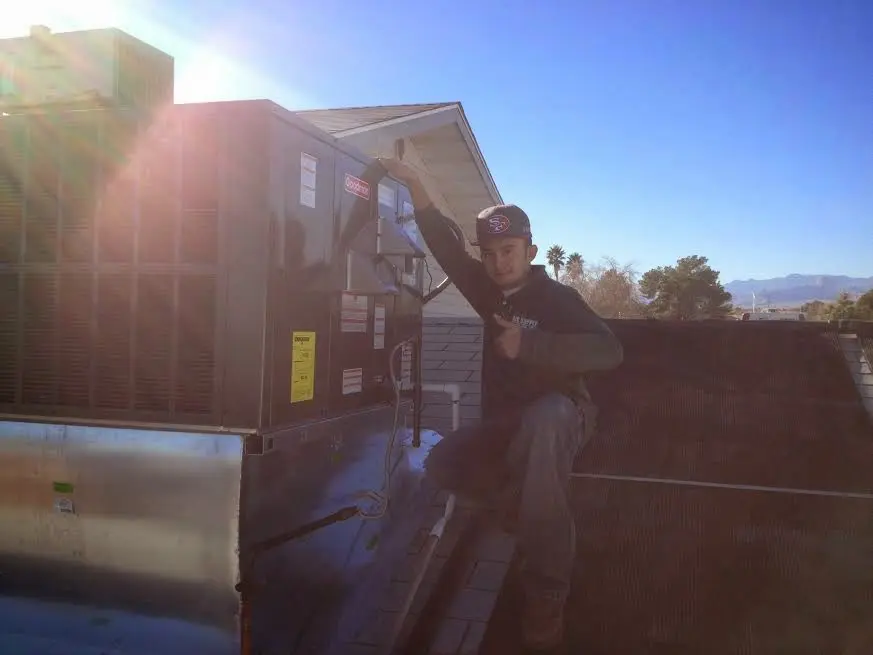 HVAC technician performing Air Duct Cleaning on a rooftop unit in Grover Beach